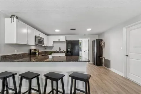 a kitchen with stainless steel appliances granite countertop a stove top oven a refrigerator a sink and a granite counter tops