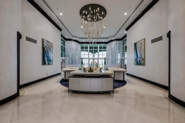 a living room with furniture chandelier and a large window