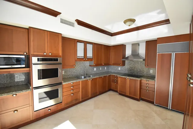 a kitchen with stainless steel appliances granite countertop a stove a refrigerator and a sink