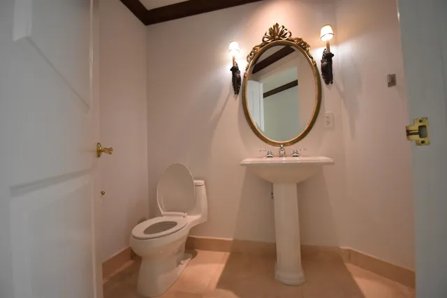 a bathroom with a toilet a sink and mirror