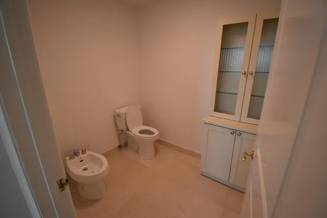 a white toilet sitting next to a bathroom sink