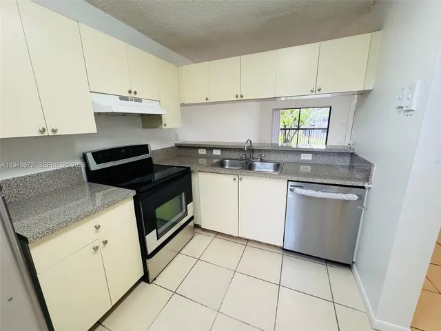 a kitchen with a sink stove and cabinets