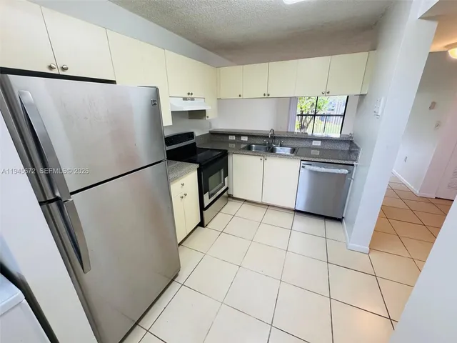 a kitchen with stainless steel appliances a refrigerator sink and microwave