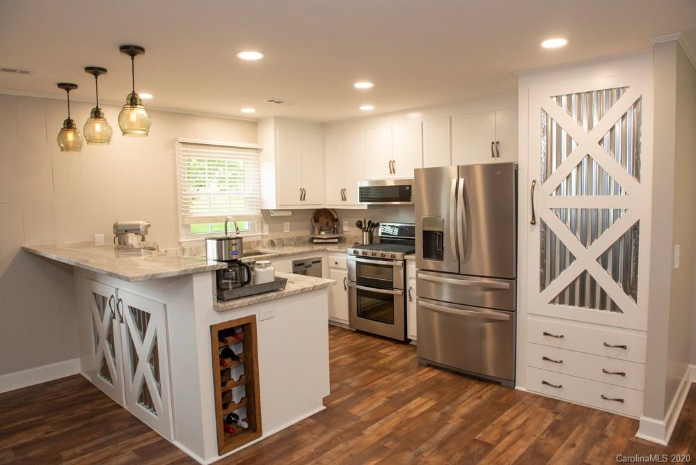 8585 Castor Road Salisbury, NC 28146 - Photo 3 of 39 a kitchen with kitchen island stainless steel appliances a sink stove and refrigerator