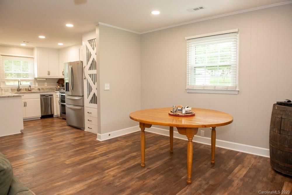 8585 Castor Road Salisbury, NC 28146 - Photo 24 of 39 a kitchen with stainless steel appliances a dining table chairs and a wooden floor