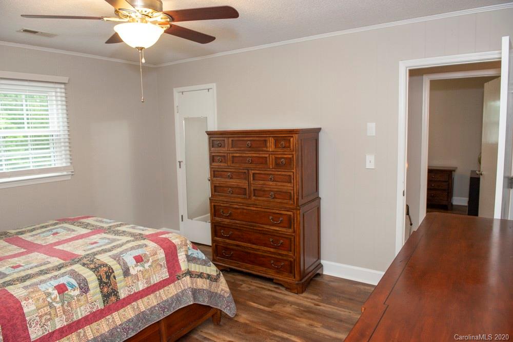 8585 Castor Road Salisbury, NC 28146 - Photo 37 of 39 a bedroom with a bed and a chandelier