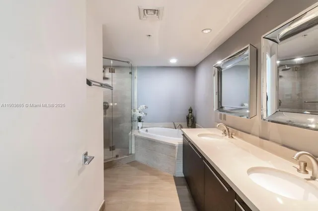 a bathroom with a granite countertop sink a toilet a mirror and shower