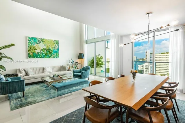 a living room with furniture a large window and dining table