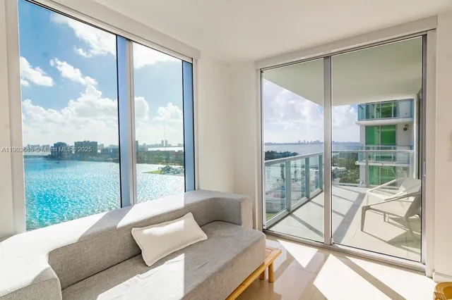 a living room with a floor to ceiling window and an outdoor view