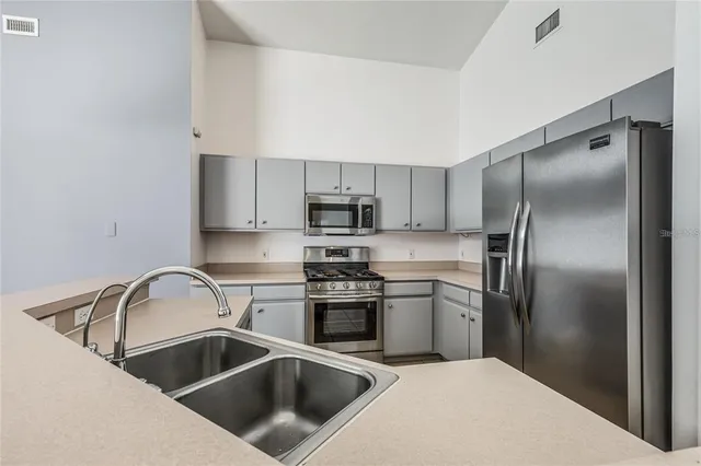 a kitchen with a sink cabinets and stainless steel appliances