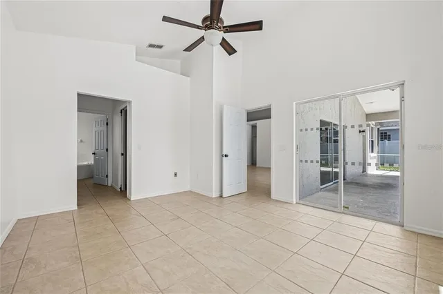 a view of a livingroom with a chandelier fan and windows