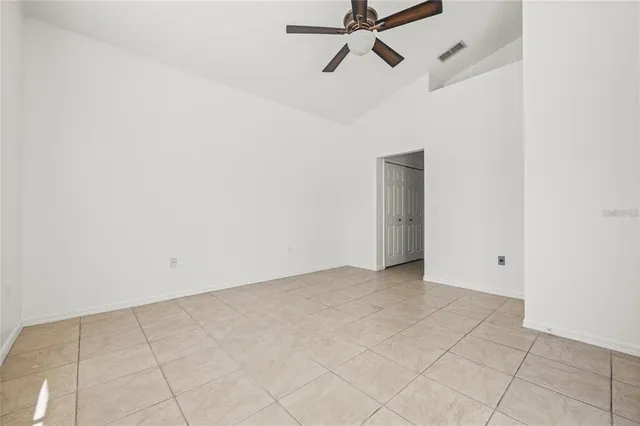 an empty room with a ceiling fan and carpet