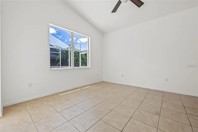 an empty room with windows and fan