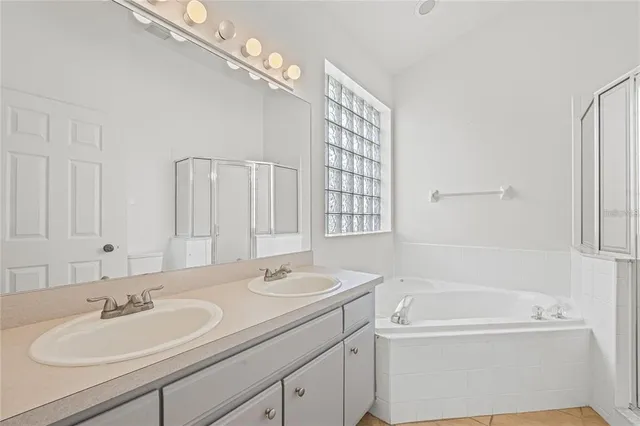 a bathroom with a tub a sink and mirror