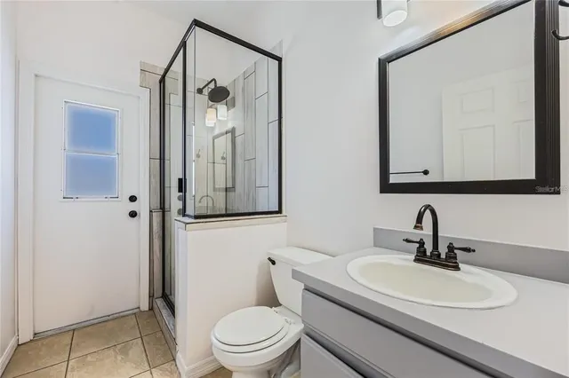 a bathroom with a toilet a sink and mirror