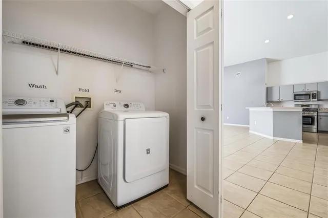 a utility room with cabinets washer and dryer