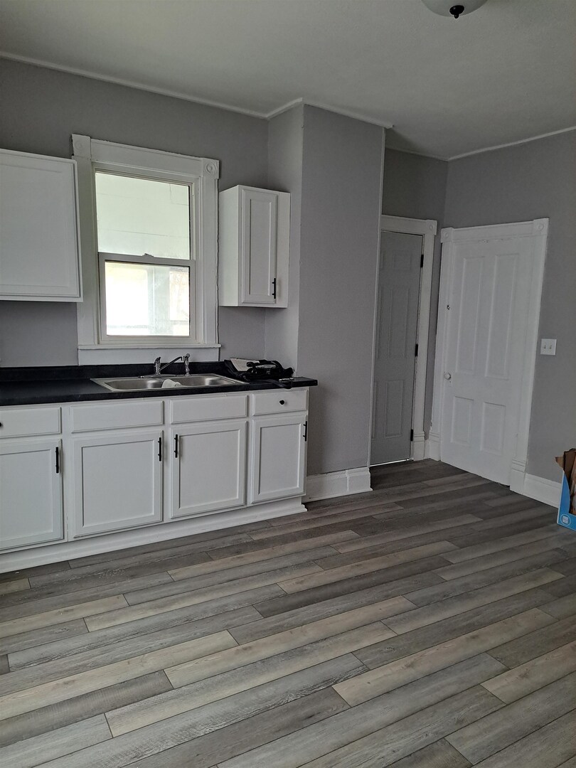 801 41st Street Rock Island, IL 61201 - Photo 4 of 8 a kitchen with granite countertop a sink cabinets and wooden floor