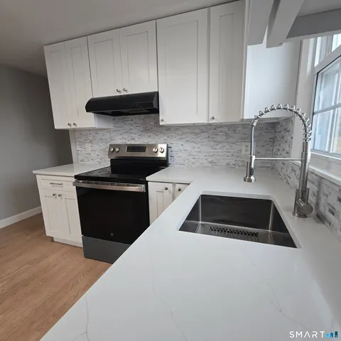 a kitchen with granite countertop a sink and a stove