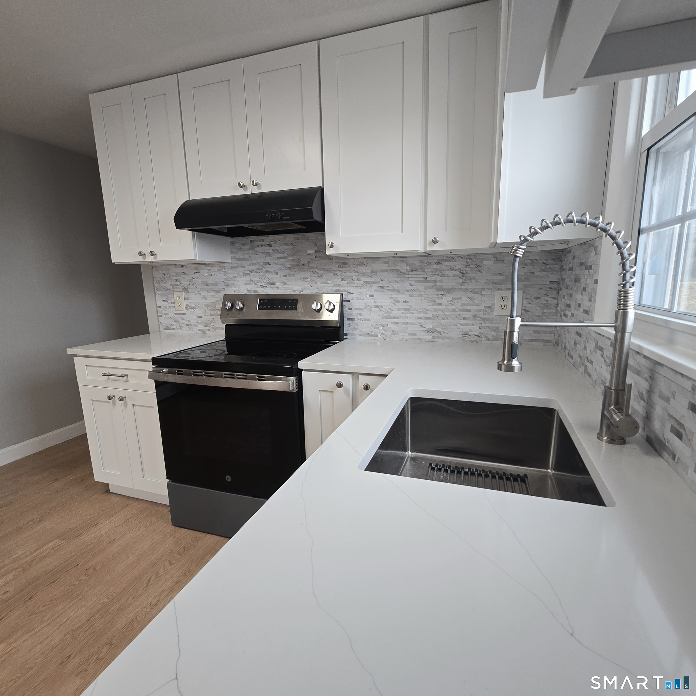 a kitchen with granite countertop a sink and a stove