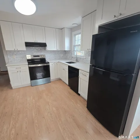 a kitchen with a refrigerator and a stove top oven