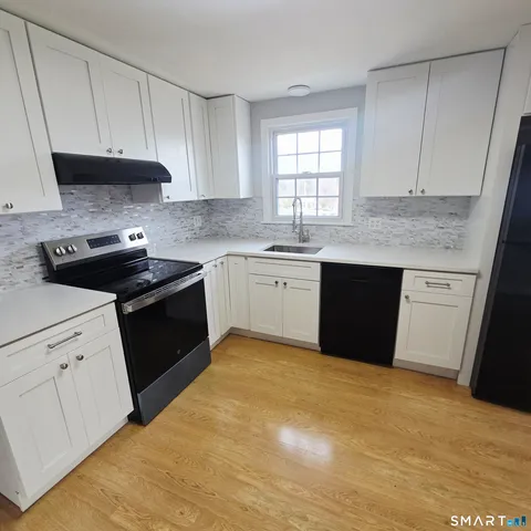 a kitchen with granite countertop cabinets sink and window