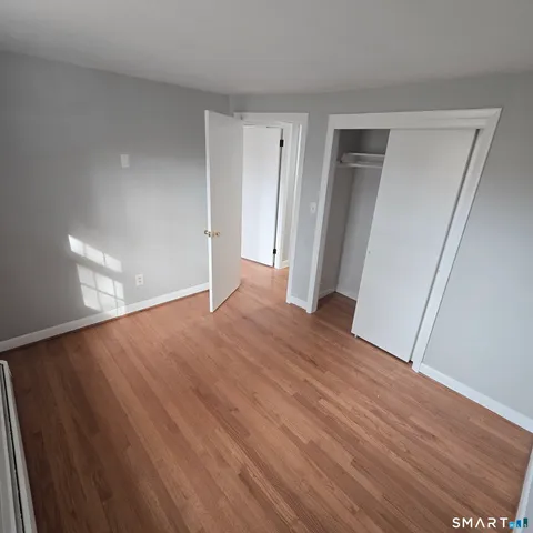 a view of empty room with wooden floor