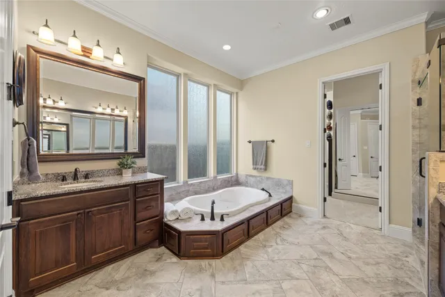 a spacious bathroom with a tub sink and mirror