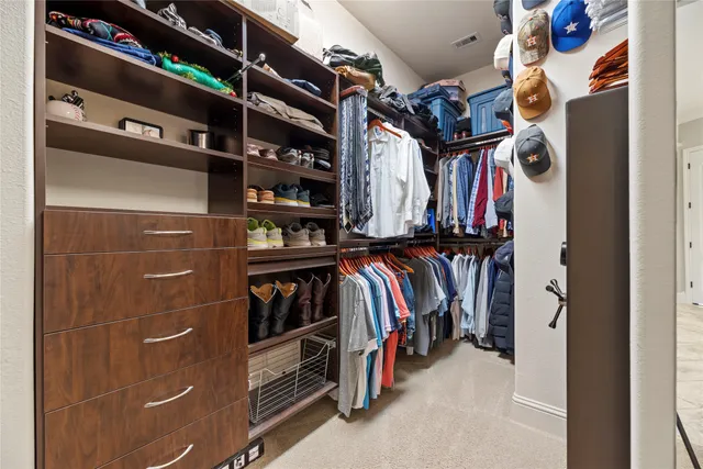 a view of walk in closet with clothes and shoes