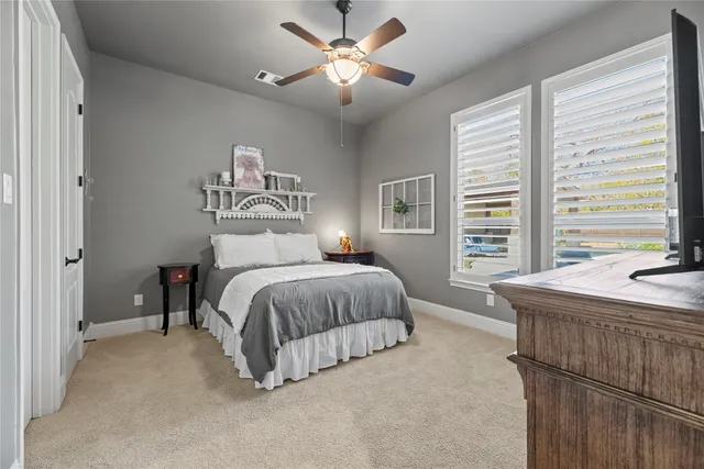 a spacious bedroom with a bed and a chandelier