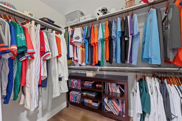 a view of walk in closet with clothes and shoes