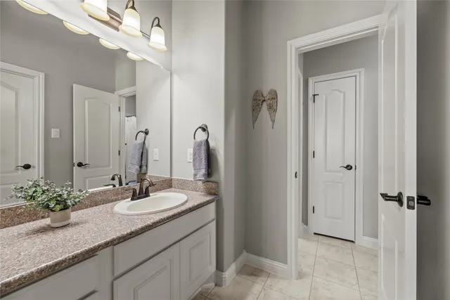 a bathroom with a granite countertop sink a mirror and a vanity