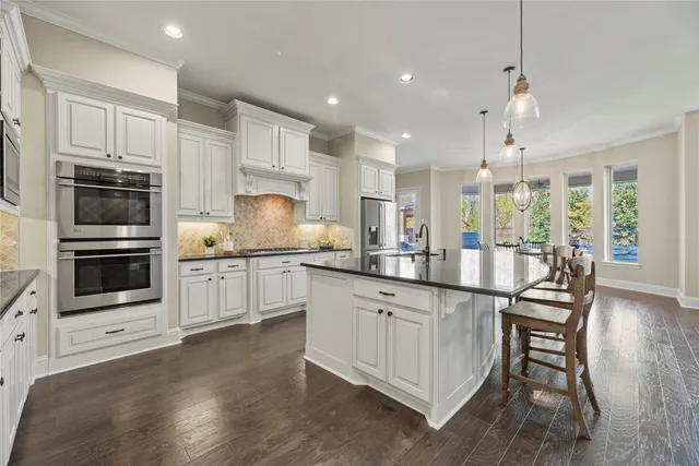 a kitchen with granite countertop white cabinets and stainless steel appliances