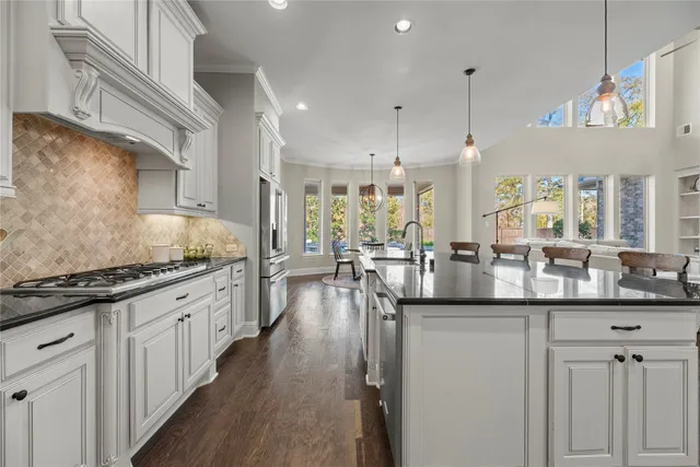 a kitchen with granite countertop a sink stove and cabinets