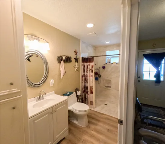 a bathroom with a granite countertop sink toilet and shower