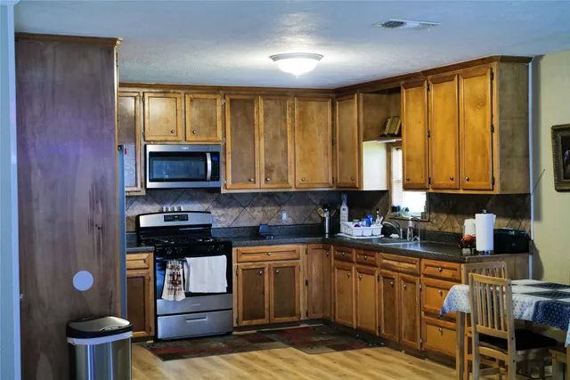 a kitchen with a stove a sink and a microwave