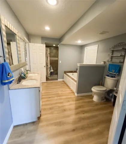 a spacious bathroom with a tub sink and mirror
