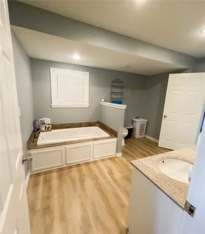a bathroom with a tub sink and a mirror