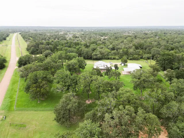an aerial view of residential houses with outdoor space and trees