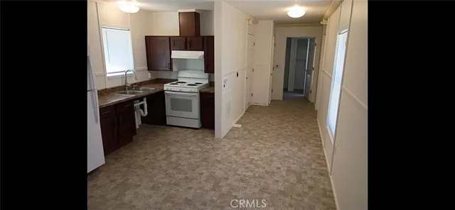 a kitchen with stainless steel appliances granite countertop a refrigerator and a stove