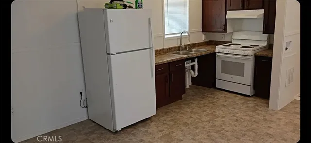 a kitchen with a stove top oven and refrigerator