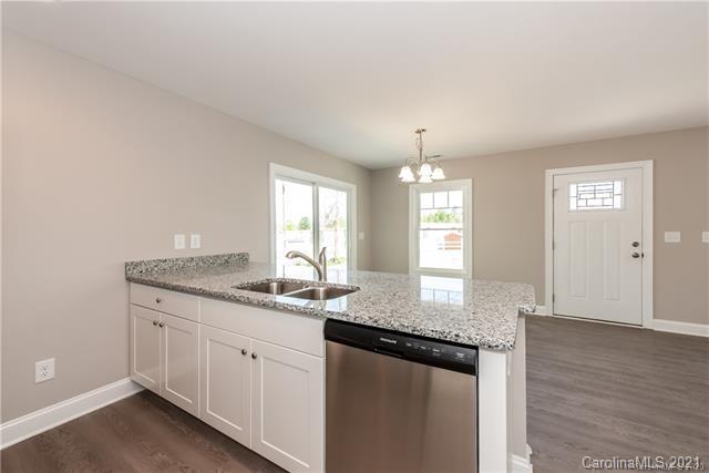 321 Salisbury Road Statesville, NC 28677 - Photo 3 of 13 a kitchen with granite countertop kitchen island a sink dishwasher a dining table and chairs with wooden floor