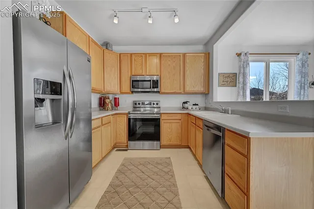 a kitchen with stainless steel appliances granite countertop a refrigerator sink and cabinets
