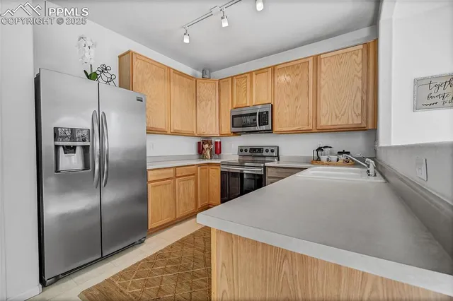 a kitchen with a refrigerator a sink a stove a microwave and cabinets