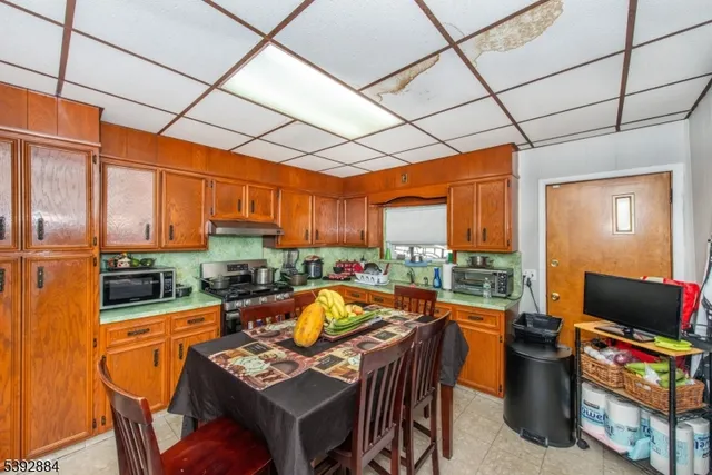 a room with stainless steel appliances kitchen island granite countertop furniture and a refrigerator