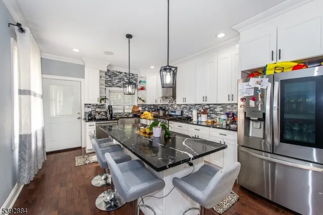 a kitchen with stainless steel appliances granite countertop a sink refrigerator and microwave