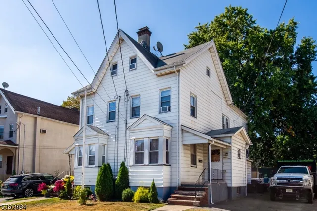 a front view of a building with cars parked