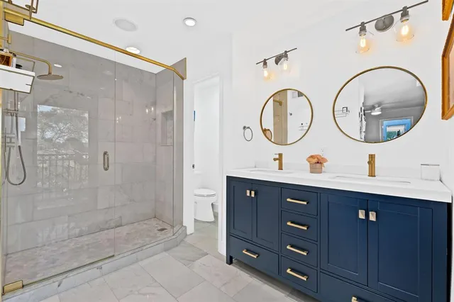 a bathroom with a double vanity sink mirror and shower