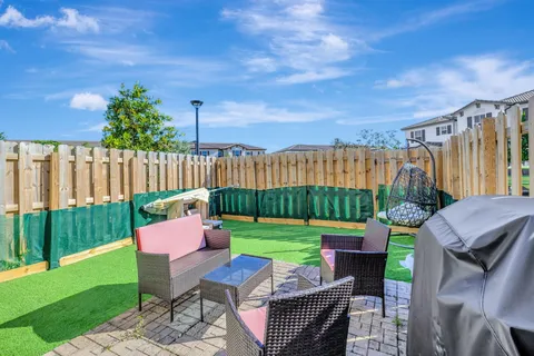 a backyard of a house with table and chairs