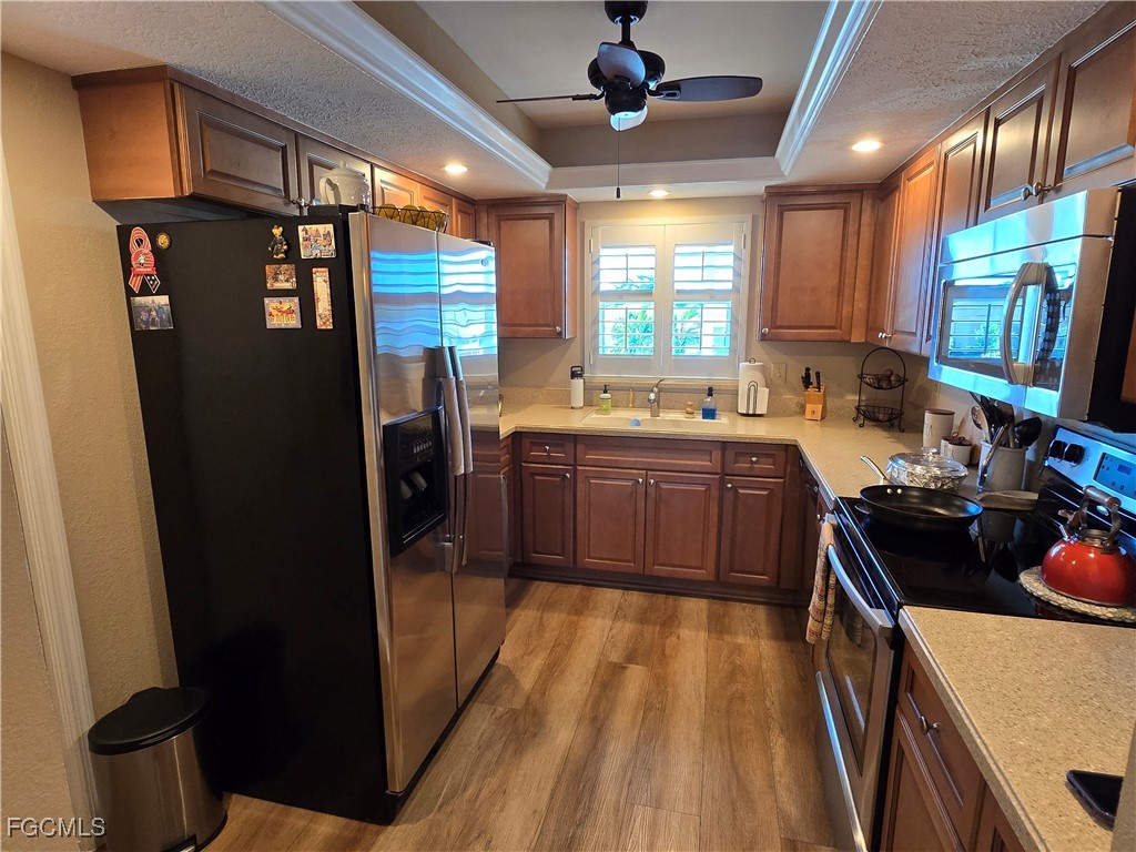 4631 Southeast 5th Avenue, Unit 207 Cape Coral, FL 33904 - Photo 5 of 19 a kitchen with stainless steel appliances a sink stove and refrigerator
