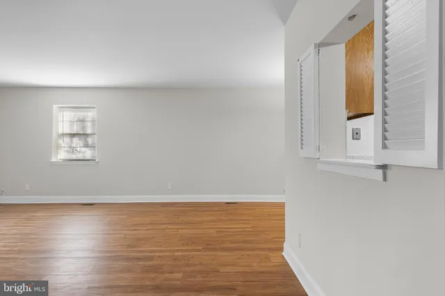 a view of a room with wooden floor and a window
